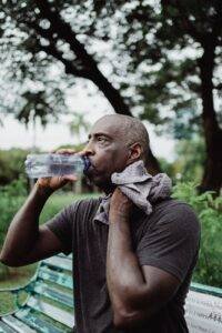 man in black crew neck t shirt drinking water from bottle